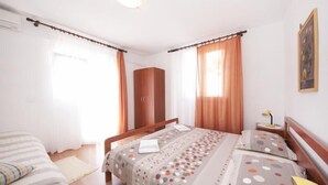 Une chambre avec deux lits, une armoire et un tableau au mur.