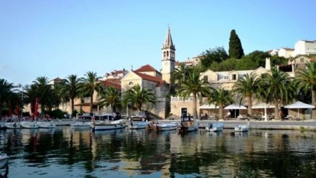 Un port de plaisance avec des bateaux, une église et des bâtiments le long de la rive.