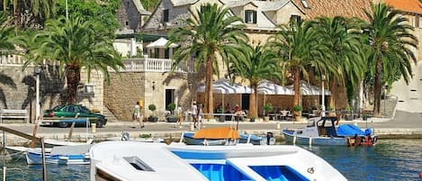A boat docked at a marina with a stone building in the background.
