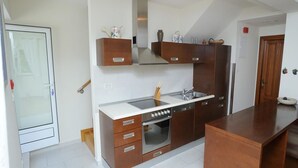 Eine moderne Küche mit Einbauofen, Kochfeld und einer großen Kochinsel.