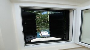 Ein Fenster mit Blick auf ein Boot und Palmen.