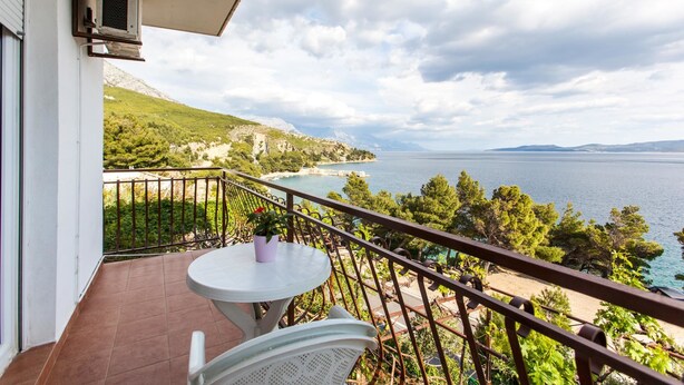 A balcony with a view of a coastal landscape, including a beach and the sea. - Apartments Blaženka (Omis)