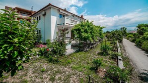 A residential building with multiple balconies, a paved driveway, and surrounding greenery. - Apartments Jasko / Two Bedroom Jasko 2 (Rab)