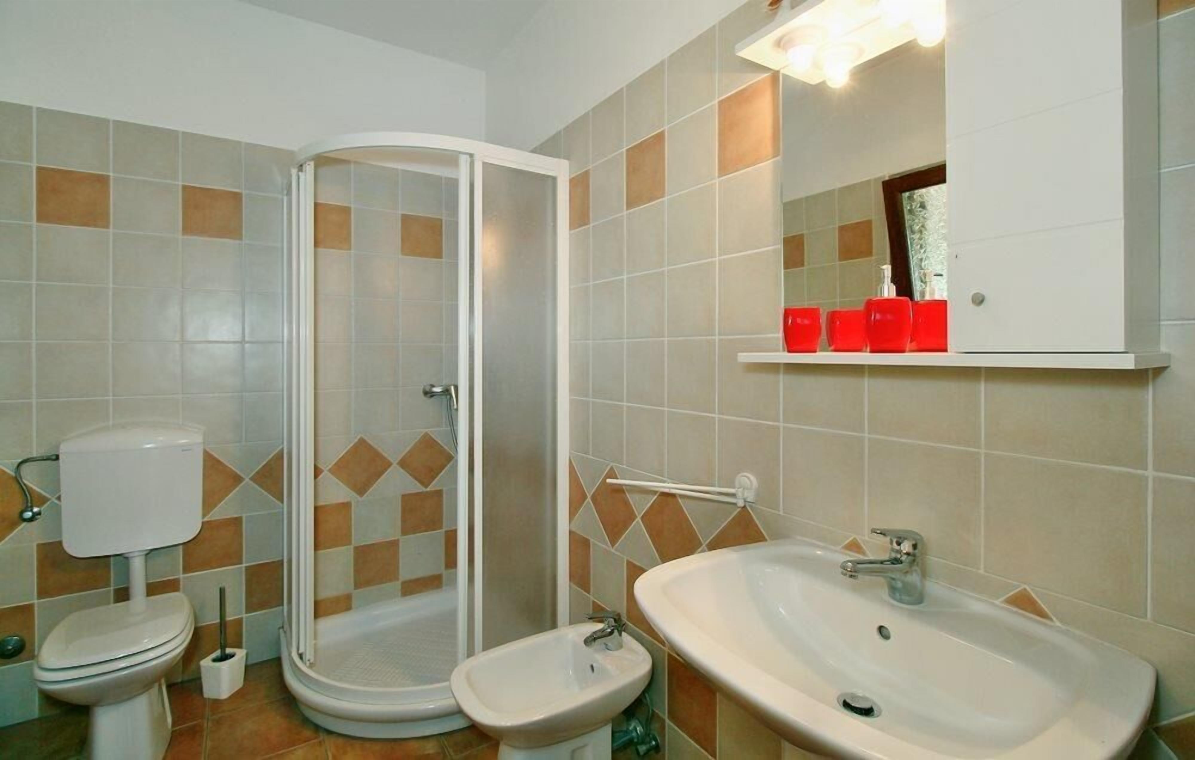 Ein Badezimmer mit Toilette, Bidet, Dusche und Waschbecken.
