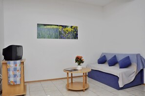 Apartment, Mehrere Betten | Wohnzimmer | Fernseher