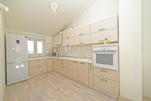 Apartment, Multiple Beds | Private kitchen | Stovetop, dishwasher, coffee/tea maker, cookware/dishes/utensils