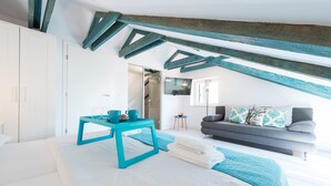Un dormitorio con cama, mesa de centro, sofá y televisión.