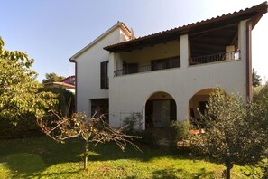 A two-story house with a balcony, arched doorways, and a garden. - Apartment Gasparini / Three Bedrooms (Pula)