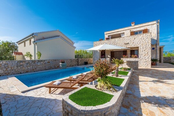 A modern house with a swimming pool, stone walls, and a well-maintained garden. - Villa St.vid 3 (Privlaka)