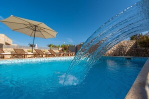 A swimming pool with a water feature, lounge chairs, and an umbrella. - Villa St.vid 3 (Privlaka)