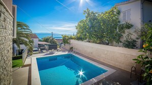 A swimming pool with a clear view of the sea in the background. - Apartments The Palms (Okrug)