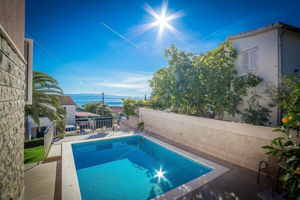 A swimming pool with a clear view of the sea in the background.