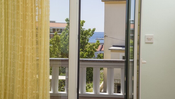 A balcony with a view of the sea and buildings. - Rooms Anđela Banjol (Rab)