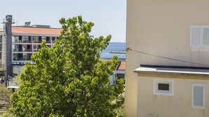 A building with a beige exterior, a visible window with shutters, and a tree in the foreground. - Rooms Anđela Banjol (Rab)