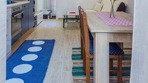 A compact living space with a kitchenette, a dining area with a table and chairs, and a sofa. - Apartment Arena (Pula)