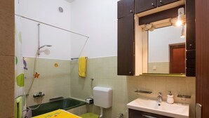 A bathroom with a bathtub, toilet, bidet, and sink. - Apartment Lili Pula (Pula)