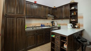 A kitchen with dark wooden cabinets, a white countertop, and a hanging light fixture. - Apartment Lili Pula (Pula)