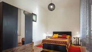 A bedroom with a bed, a wardrobe, a mirror, and a hanging light fixture. - Apartment Lili Pula (Pula)