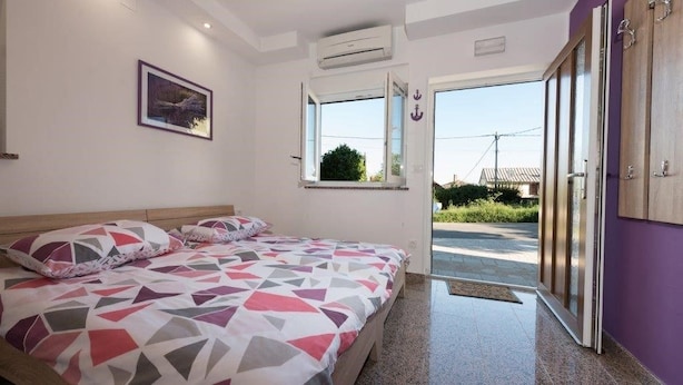 Ein Schlafzimmer mit Bett, Fenster und Klimaanlage.