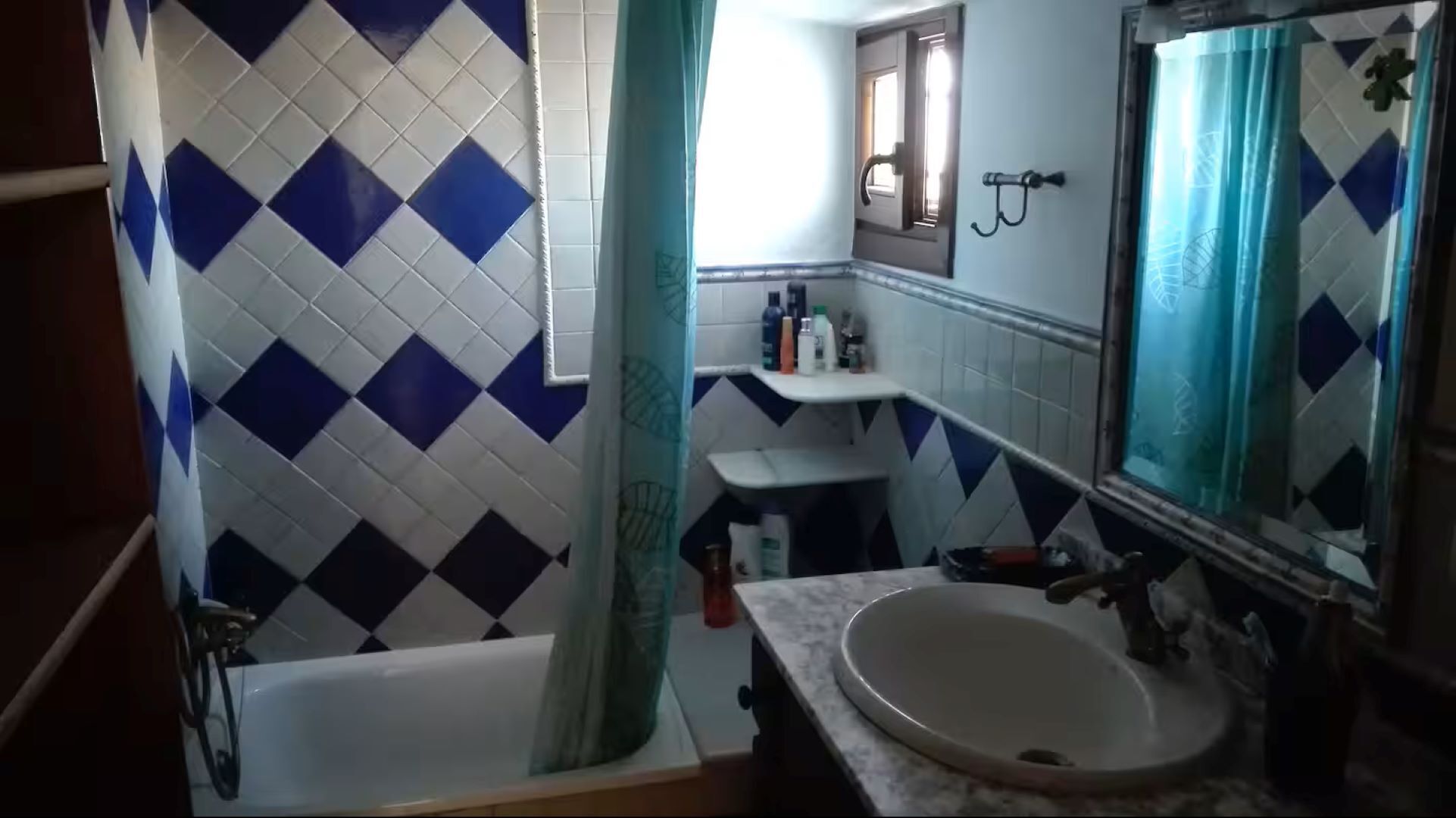 Een badkamer met een bad, een wastafel en een spiegel.