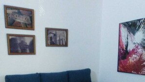Ein Wohnzimmer mit einem blauen Sofa, einem kleinen Holztisch und einem Schachbrettmuster-Boden.
