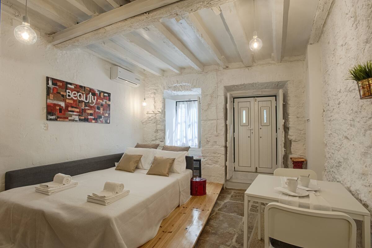 Un dormitorio con cama, mesita de noche y un cuadro en la pared.