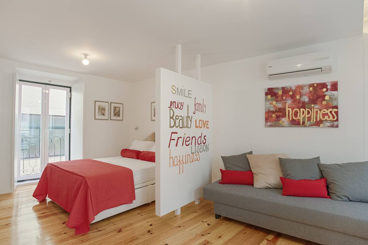 Un dormitorio moderno con cama, sofá y una pared con mensajes positivos.