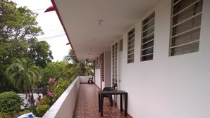 A covered balcony with a tiled floor, a table, and chairs. - Posada Rocky 2 (San Andrés)