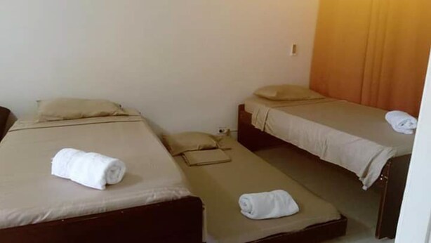 A room with two single beds, each with a pillow and a rolled towel. - Posada Rocky 2 (San Andrés)