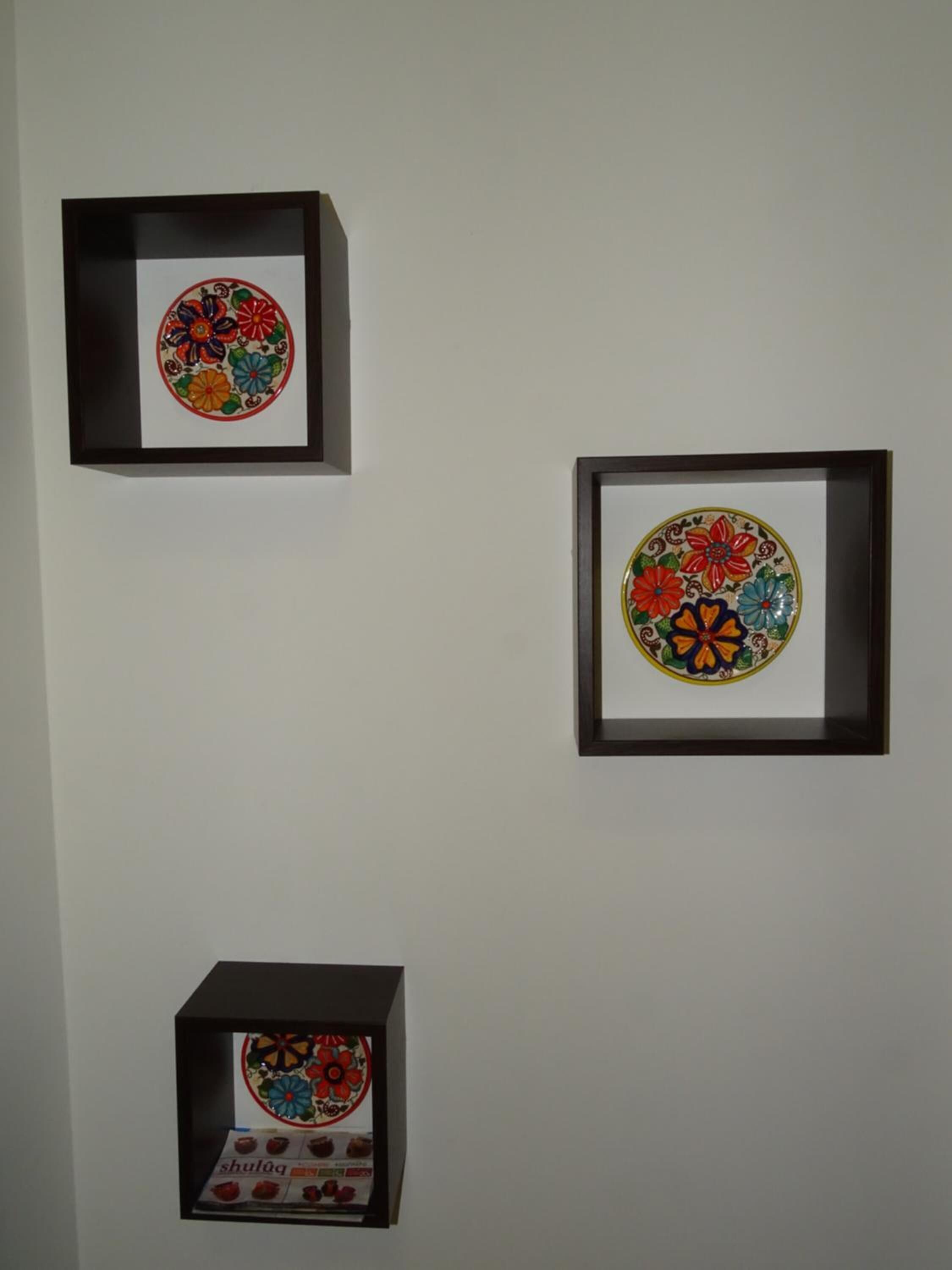 Tres obras de arte enmarcadas en una pared.