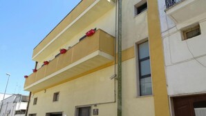 A two-story building with balconies, a door, and a window. - B&B Soleluna (Veglie)