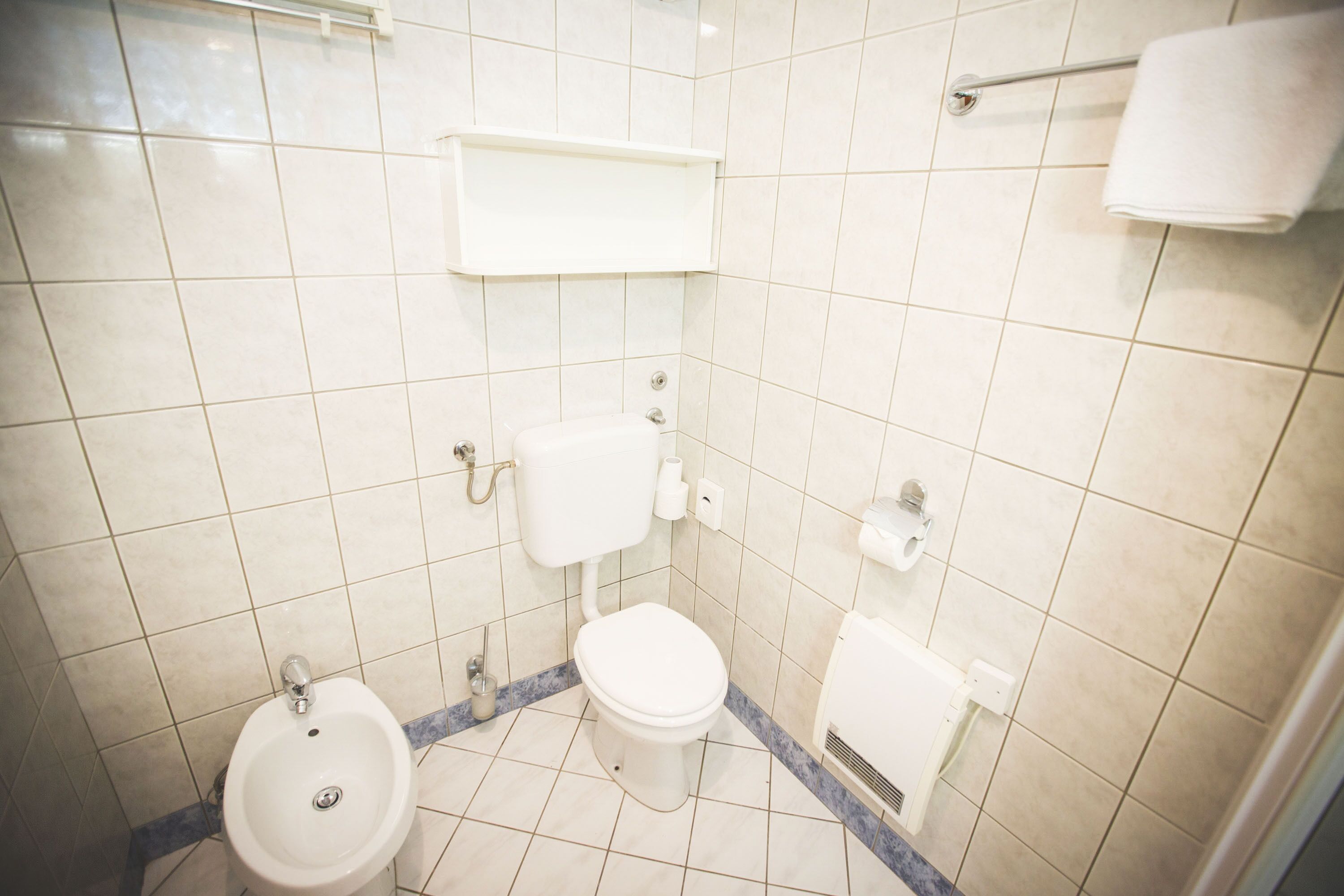 A bathroom with a toilet, bidet, and sink.