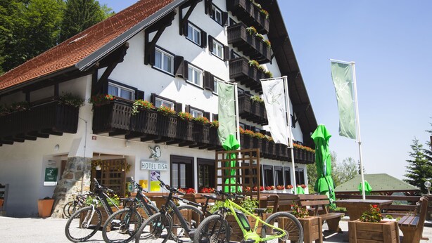 A traditional building with a sign reading "HOTEL TISA," outdoor seating, and bicycles parked in front. - Hotel Tisa (Hoce-Slivnica)