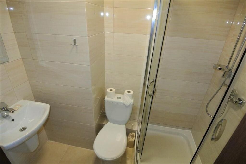 A bathroom with a toilet, sink, and glass-enclosed shower.
