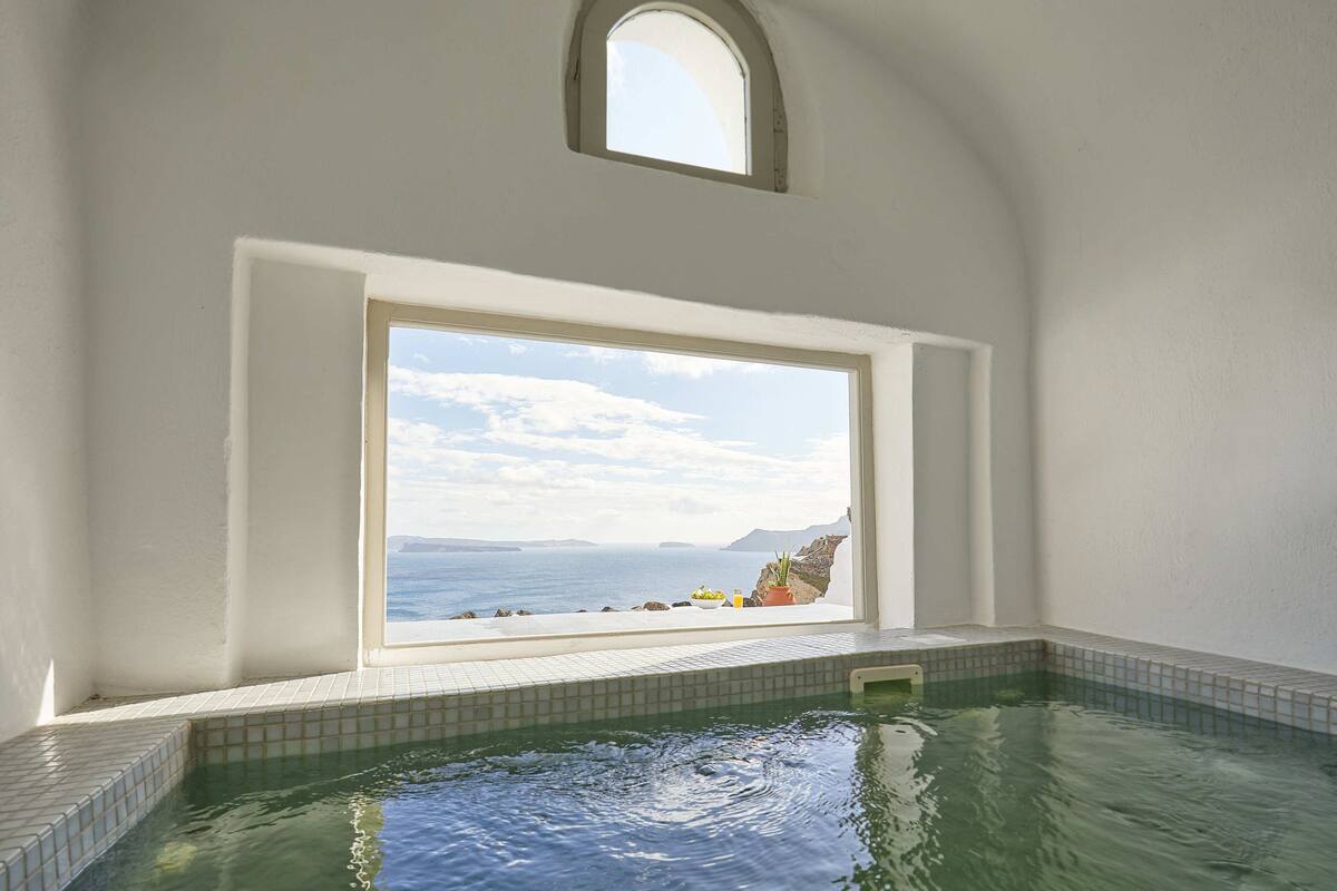Ein Wellnessbereich mit großem Fenster und Blick auf die Küste.