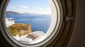 A view from an airplane window of a coastal area with white buildings and a body of water. - Diamond Luxury Suites Collection (Santorini)