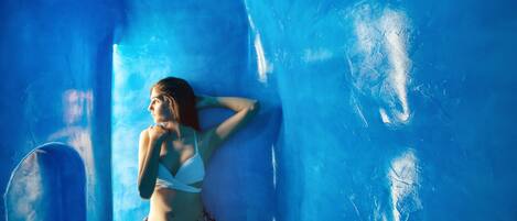 A person in a bikini standing in a blue, ice-like structure.
