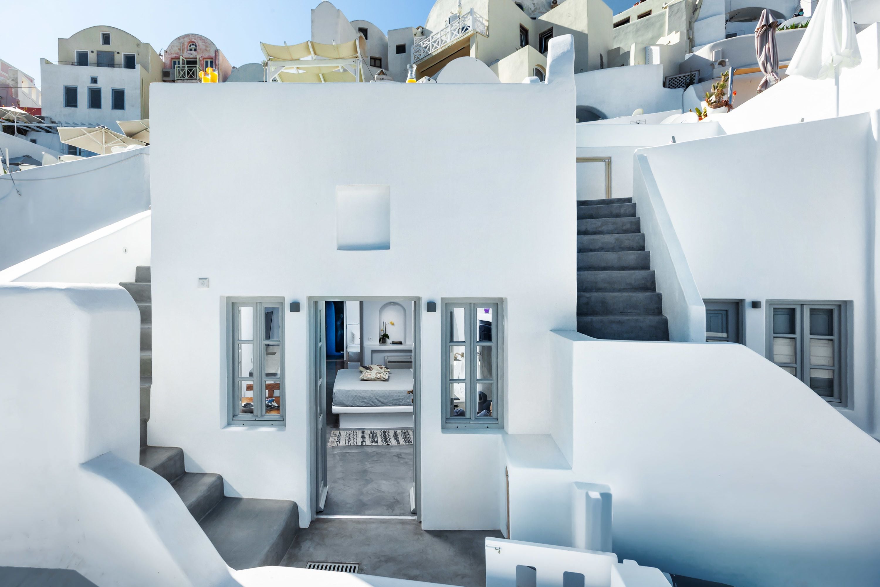 Habitación de hotel moderna y compacta, con cama, una pequeña zona de estar y vistas de los edificios circundantes.