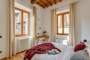 Una camera da letto con un letto, una scrivania, una sedia e un termosifone.