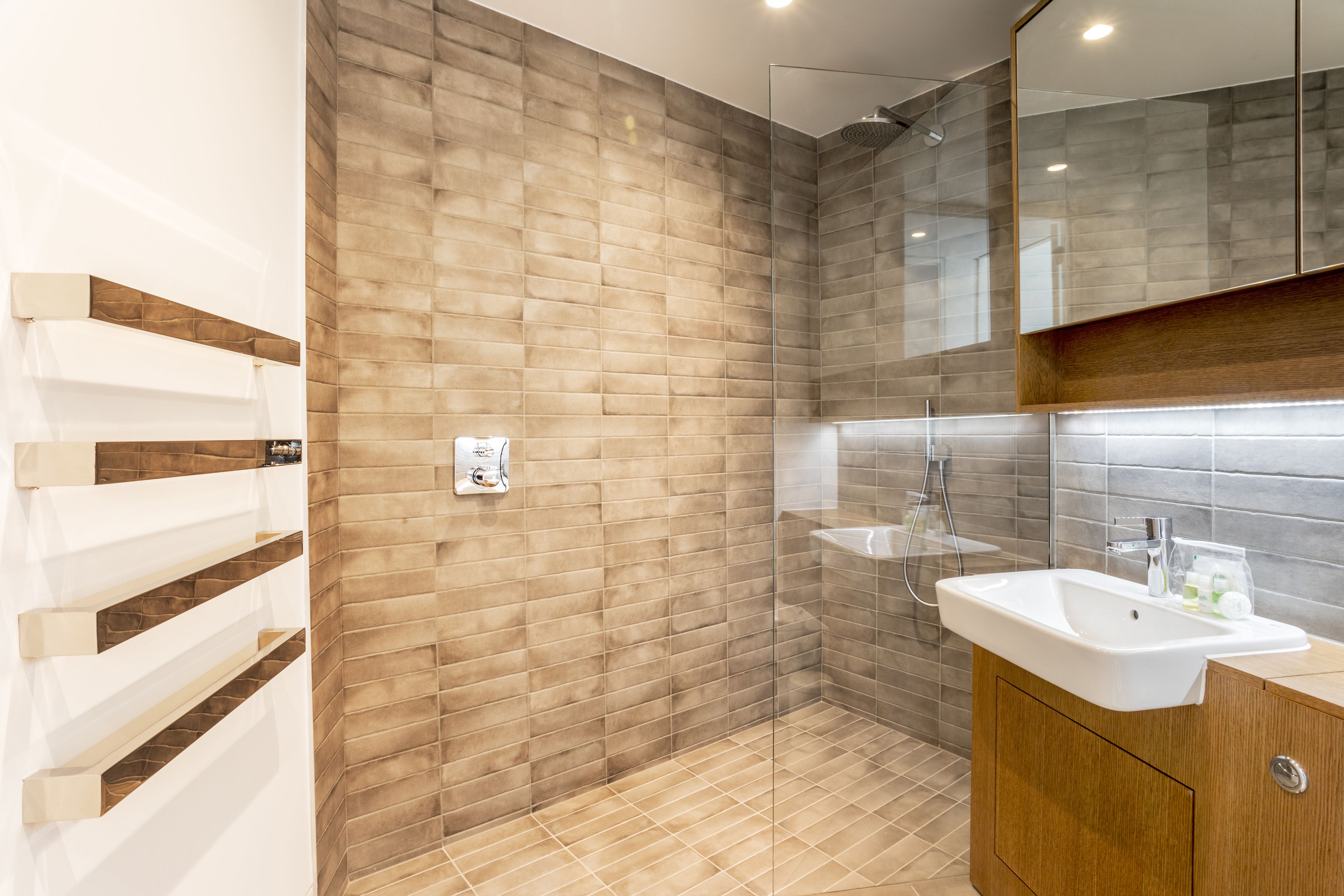 A modern bathroom with a shower, a sink, and a mirror.