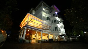 A multi-story building with a prominent entrance and a covered area. - DVI Hotel & Resorts (Devikolam)
