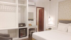A bedroom with a large bed, a desk with a chair, a wardrobe, and a hanging light fixture. - Hanoi A83 Hotel (Hanoi)