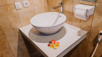 Un bagno con un lavandino bianco, uno specchio e un porta carta igienica.