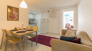 Un espacio habitable compacto con comedor, kitchenette y sofá.