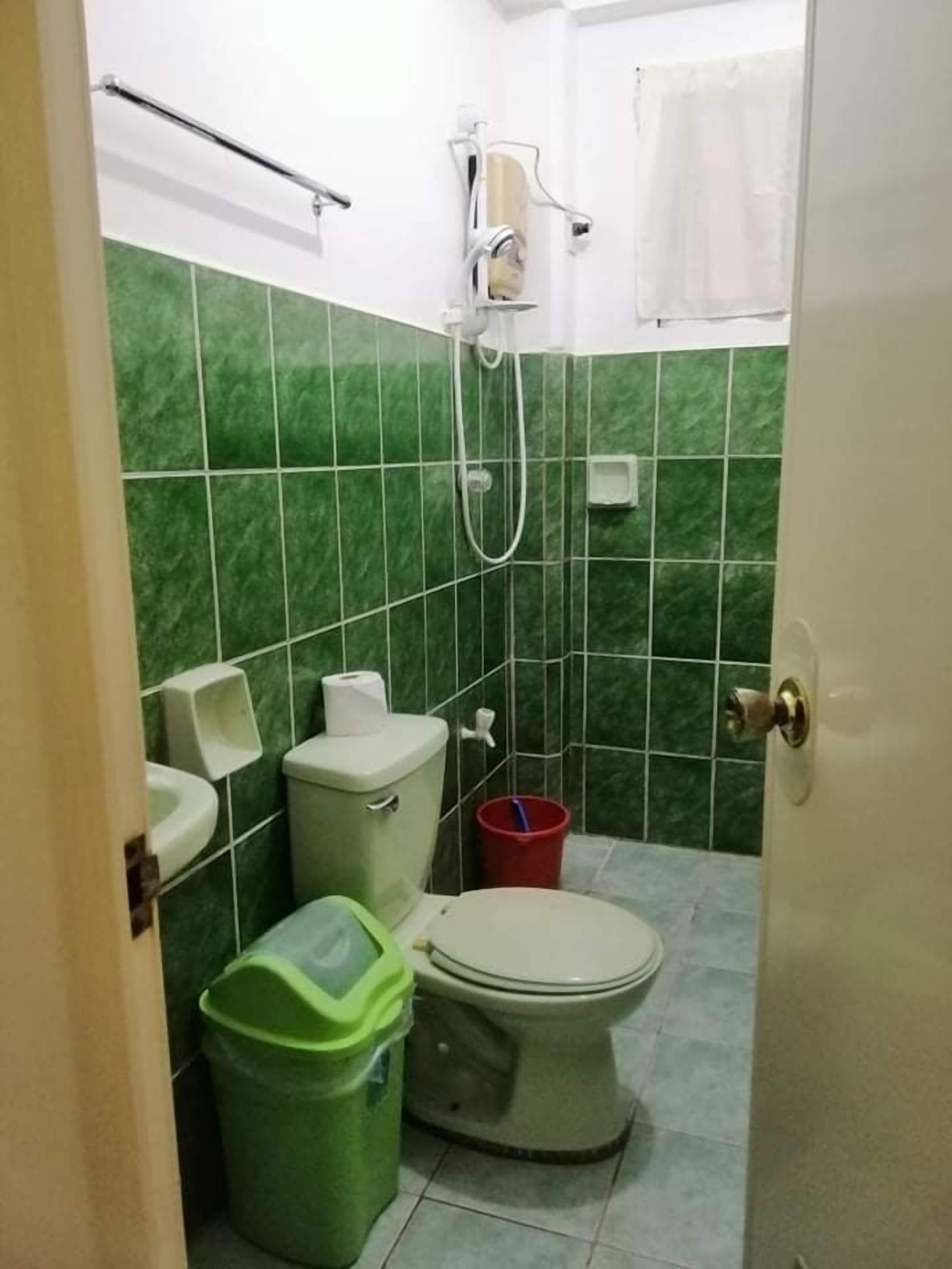 Um banheiro pequeno com vaso sanitário, mictório e chuveiro.
