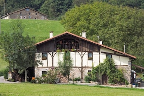 A traditional chalet with a stone facade, wooden beams, and a sloped roof.