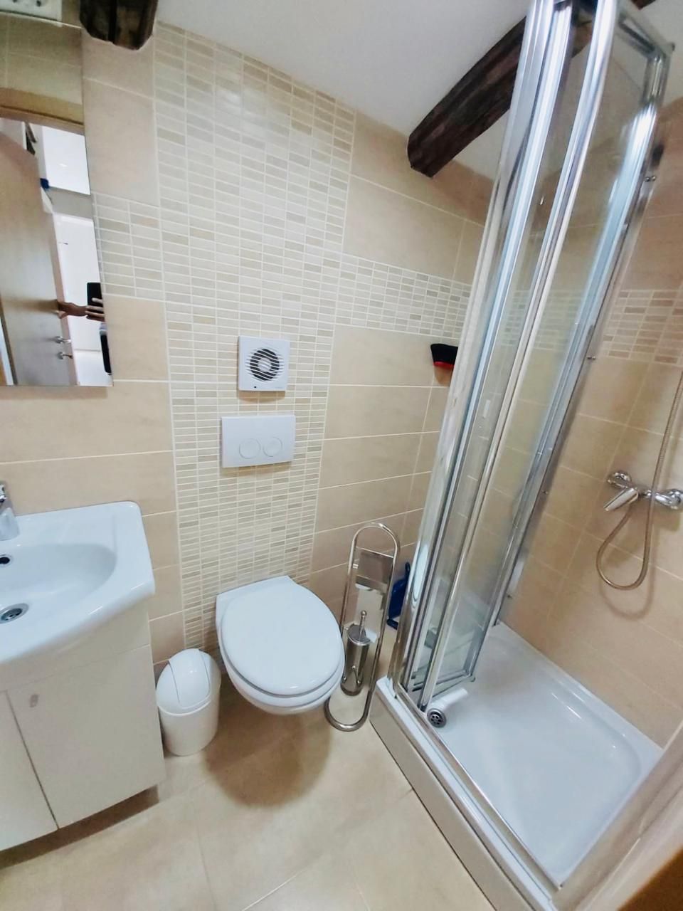 A bathroom with a toilet, sink, and shower.