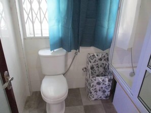 Luxe appartement | Badkamer | Een bad/douchecombinatie, handdoeken, zeep, toiletpapier