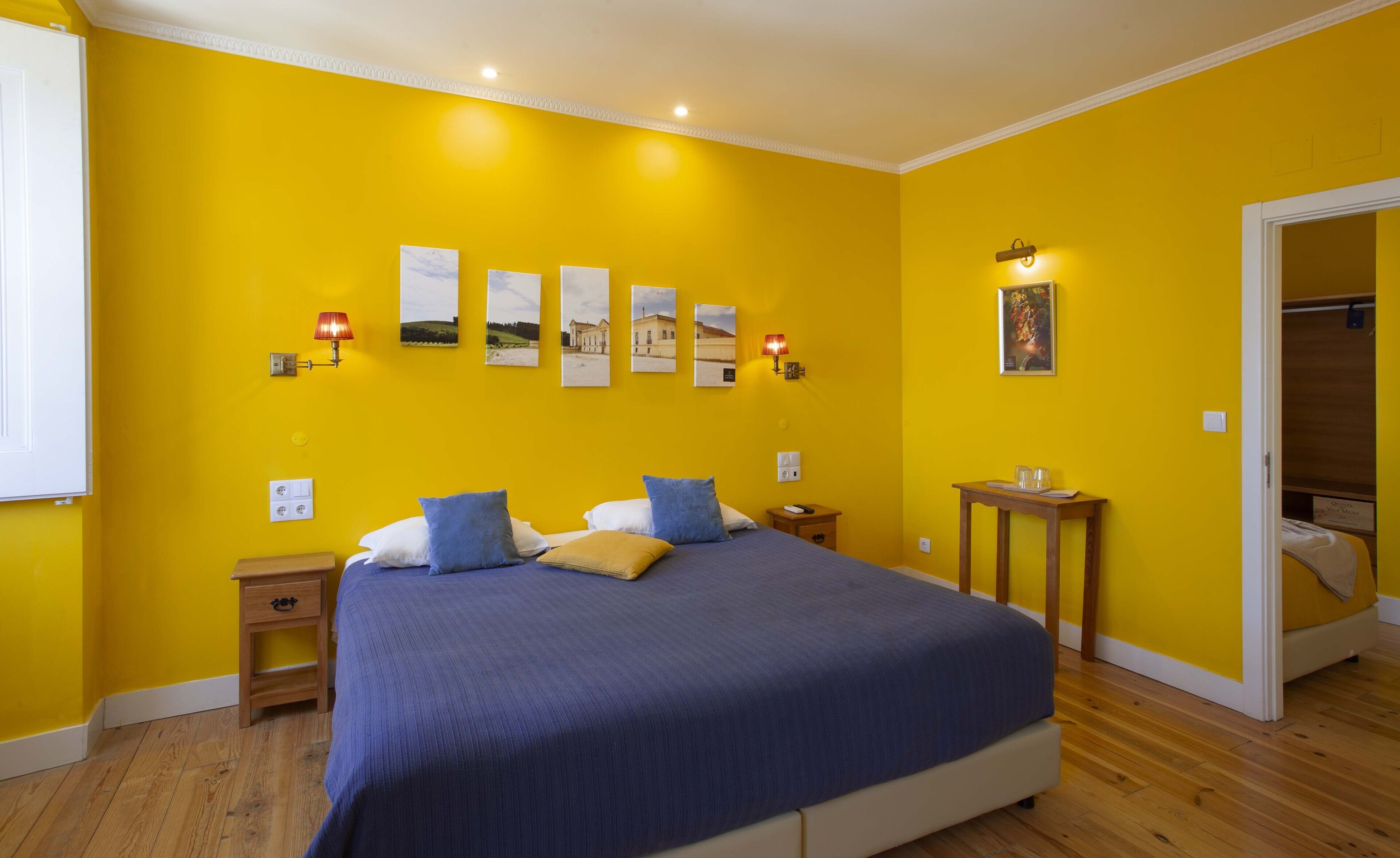 A bedroom with a large bed, wooden nightstands, a bedside table with glasses, and a wardrobe.