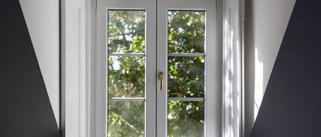 A dormer window with a view of trees.